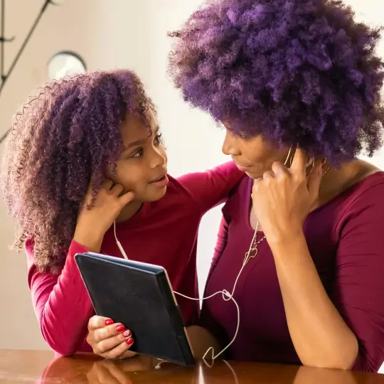 Mother and child daughter listening to something together